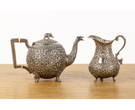 Indian Cutch teapot and similar jug late 19th Centuryboth with chased detail throughout with scrolling leaves and floral patt