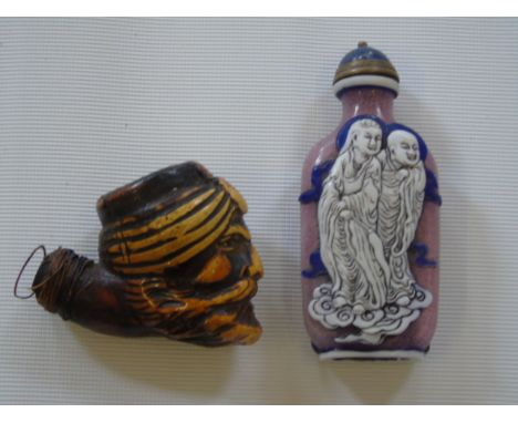 An Oriental snuff bottle and a carved pipe bowl in the form of a man's head.