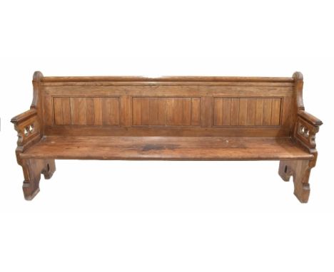 19th century pitch pine pew bench seat, with panelled back and pierced gothic carved arms over the planked seat upon trestle 