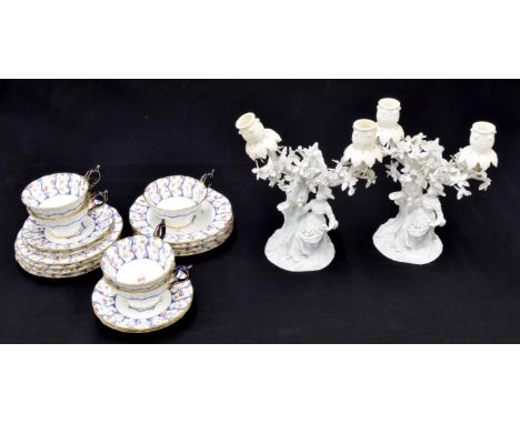 Pair of Meissen white glazed figural porcelain candelabra, each modelled with a lady picking fruit, blue crossed swords mark,