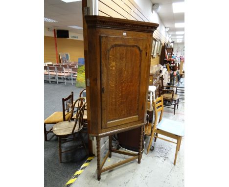 Antique oak corner cupboard with a four-shelf, two-drawer interior on a later turned leg stand