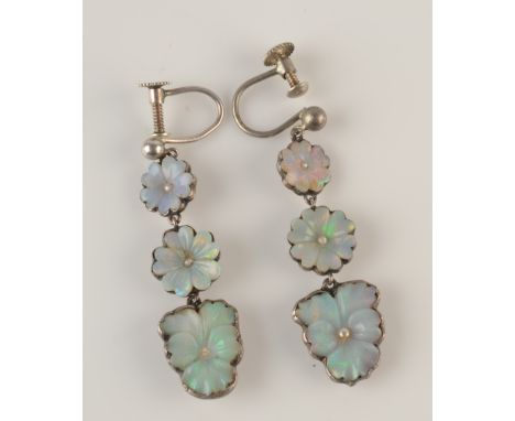 A pair of silver earrings, each with three carved opal flowerheads, the centre of these, each has a tiny pearl.