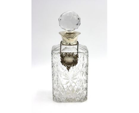 A silver mounted cut glass decanter, together with a silver Whisky decanter label ornately decorated with a grape vine. 