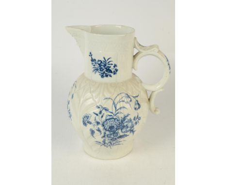A massive 18th century Caughley blue and white cabbage moulded jug with mask spout, decorated with unusual groups of flowers,