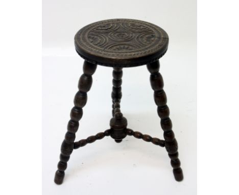 A carved oak stool, on bobbin turned legs, height 55cm.