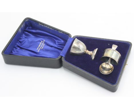 A silver child's christening set, comprising an eggcup, a spoon and a napkin ring, cased, various dates.