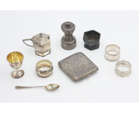 A cased three piece silver christening set comprising an egg cup, spoon and napkin ring, together with a silver pepper mill, 