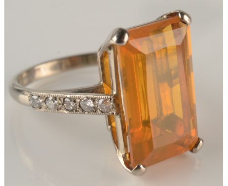 A white gold ring set a large emerald cut fire opal with diamond set shoulders. Condition report: No condition issues.Ring Si