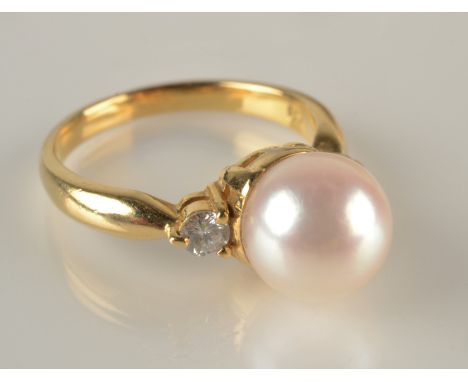 An 18ct. gold ring set an 8.4mm pearl flanked by diamonds.
