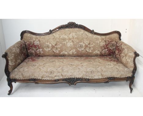 A large early Victorian rosewood sofa, the floral decorated paddedback, arms and seat, scroll carved arms on floral carved ca