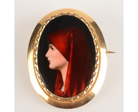 An 18ct gold mounted brooch set with a miniature enamelled portrait of a lady with a red shawl. Condition report: Some rubbin