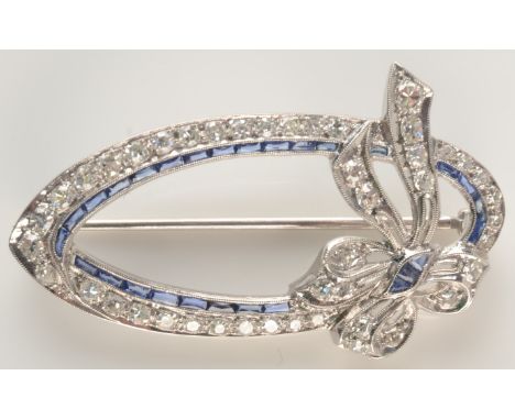 A white gold diamond set elliptical bow brooch tied with a bow, an inner line of calibre set sapphires, further calibre set s