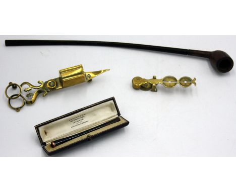 A church warden's pipe, a brass candle snuffer, a brass sovereign balance by Harrison and a gold mounted amber cigarette hold