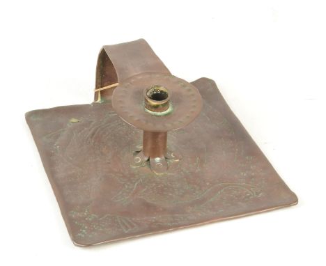 An Arts and Crafts copper chamber candlestick, with overhead handle and simple cylinder holder, repousse decorated with two s