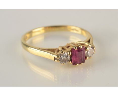 An 18ct gold ring set an emerald cut ruby and two diamonds.