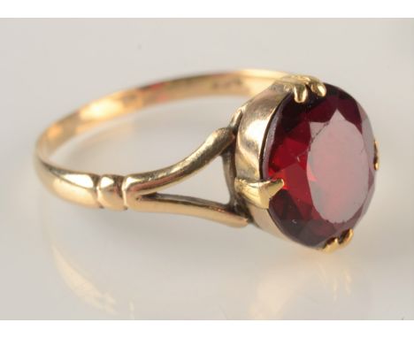 A 9ct gold ring set a red stone.