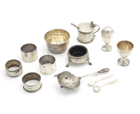 Four silver napkin rings, a tea strainer and stand, a swizzle stick and various condiments, 15oz excluding the two blue glass