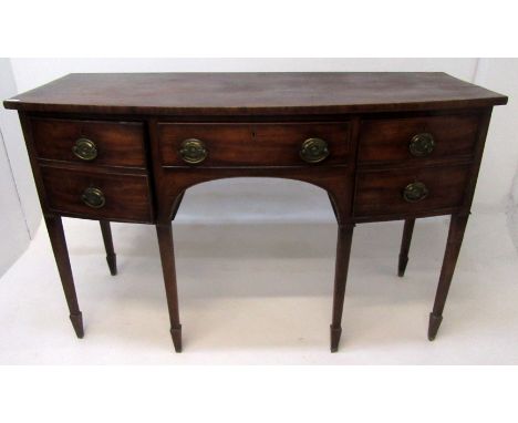 A George III mahogany bow front sideboard, with a central frieze drawer flanked by a pair of cupboard doors, each as two dumm