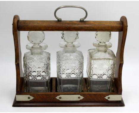 A tantalus and a cocktail decanter. Condition report: One of the decanters from the tantalus is broken at the neck.