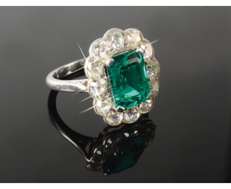 A fine and impressive emerald and diamond cluster ring, the central emerald cut natural emerald of very high quality and appr