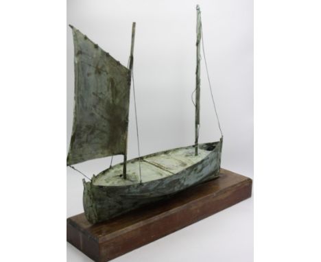 An early 20th century copper weather vane, in the form of a Cornish lugger, mounted on an oak stand, height 56cm, length 60cm