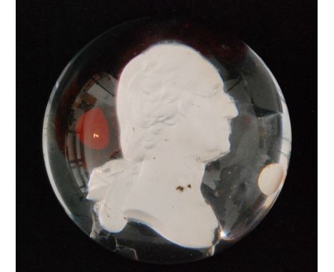 A 19th Century clear crystal paperweight, possibly French, with a shallow dome internally decorated with a sulphide profile p