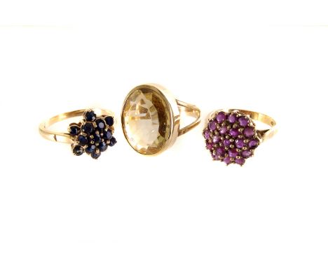 Two 9ct gold cluster dress rings, one with red and one with blue stones, together with a citrine dress ring in yellow metal (