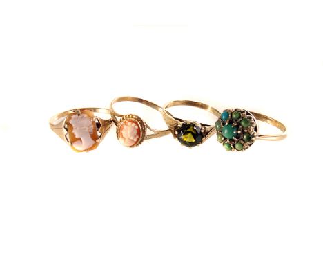 A group of four 9ct gold rings, including two cameo examples, a turquoise bead cluster ring and a green stone solitaire ring 