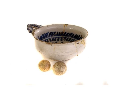 A Delftware porringer,  the white underglaze over painted with dark blue foliate decoration, 13cm diameter, together with two