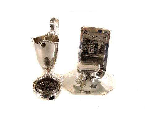 A late Victorian silver helmet shaped cream jug by TW, together with a silver photograph frame, a George V silver capstone in