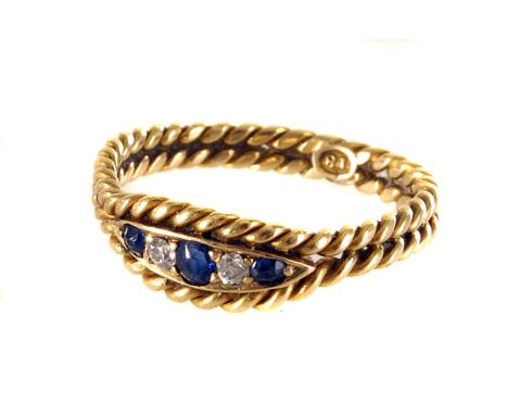 An 18ct marked sapphire and diamond ring,  rope twist design centre with three sapphires and two old cut diamonds 