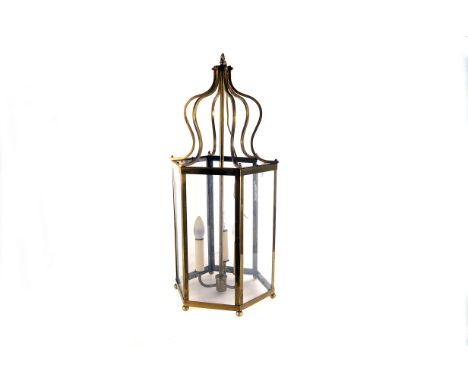 A brass and glass hexagonal ceiling lantern, the brass and glass frame with tri-light section to centre 