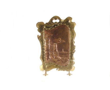 An Arts and Crafts style copper and brass fire screen,  shaped mount with scene of castle by the sea  