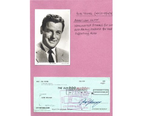 Gig Young signed personal cheque attached to page with corner tabs. American actor. Good condition. All autographs come with 