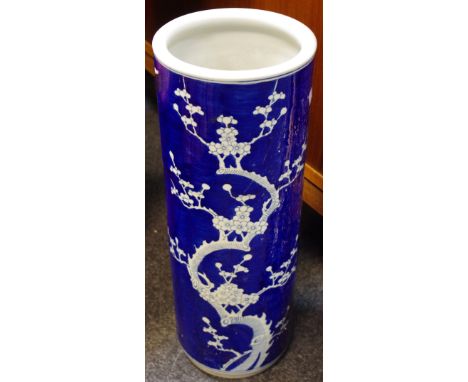 A Chinese blue and white cylindrical stick stand, decorated with blossoming prunus