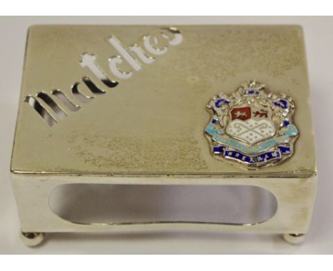 An Edwardian silver novelty matchbox holder, pierced inscription Matches, applied with an enamel coat of arms, bun feet, 7.5c