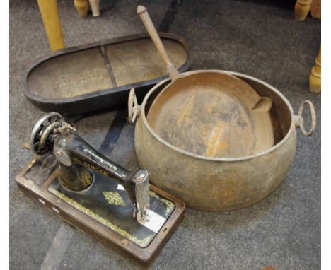 A cast iron feeding trough; a cast iron skillet; a cast iron pan; a Singer sewing machine (4)