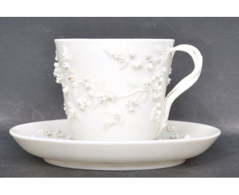 A 19th Century Victorian Royal Worcester blanc de chine tea cup and saucer having raised floral sprays with the handle moulde