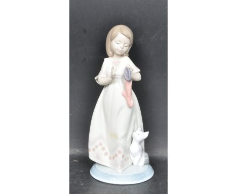 A ceramic porcelain Spanish Lladro figure entitled 'A Stocking for Kitty' from The Night Before Christmas collection. Figurin