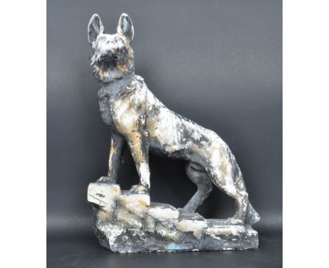 A vintage 1930's large Art Deco chalk ware figure of a German Shepherd being raised on a naturalistic plinth facing left. Mea