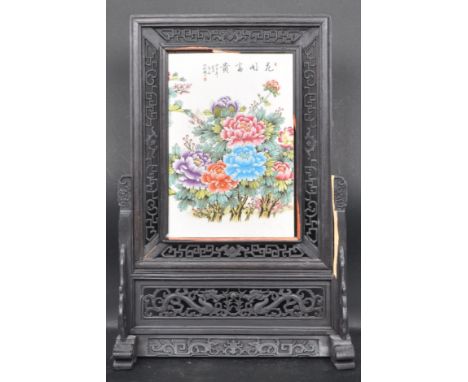 A Chinese style hardwood ceramic table screen. Having a signature, floral pattern to the body and removable panel. Measures: 