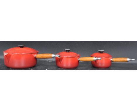 A collection of three vintage 20th century Le Creuset pans of graduating size in red enamel. Largest pan measures 30cm wide. 