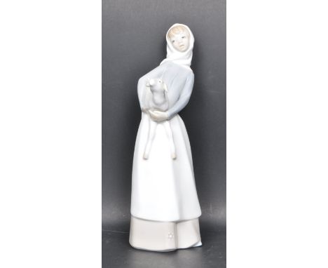 A vintage 20th century porcelain Lladro figurine of a girl carrying a lamb. Measures 30cm high. Makers stamp to the underside