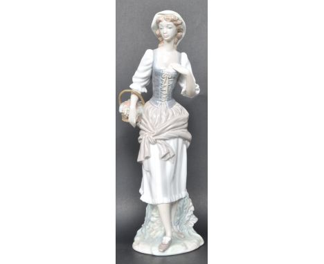 A vintage 20th century porcelain Lladro figurine of a girl wearing a corset carrying a basket. Measures 30cm high. Makers sta