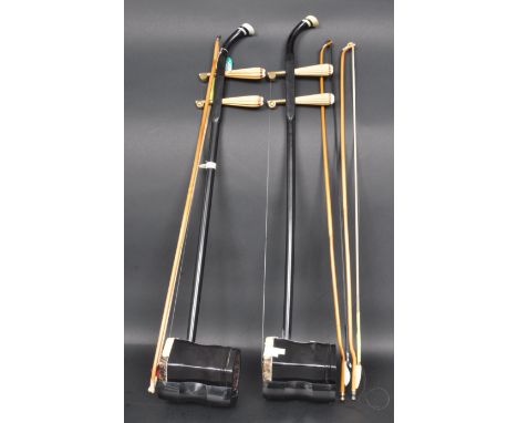 Two 20th century Chinese oriental Ehu musical instruments. Both items having ebonised body and fingerboard with bone insertio