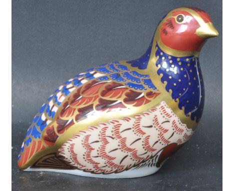 A Royal Crown Derby porcelain ceramic bird paperweight in the form of a partridge. Signed to base by Hugh Gibson and is a lim