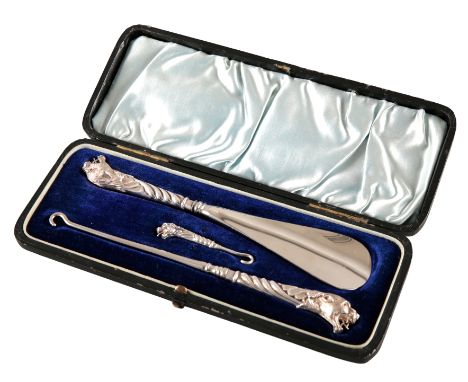 A GEORGE V SILVER THREE PIECE SHOE HORN AND BUTTON HOOK SETby Adie & Lovekin, Birmingham 1898, the tiger terminals with red g