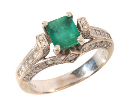 AN EMERALD AND DIAMOND RINGin 18ct white gold, set with a step cut emerald of c.0.95 carats to a stylised band set throughout