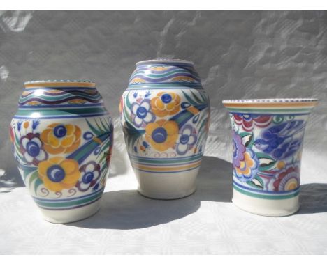 Three early to mid 20th century Poole Pottery vases, each typically decorated in floral patterns with impressed marks to the 