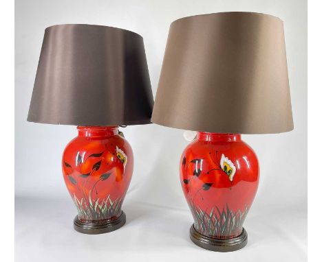 PAIR POOLE POTTERY TABLE LAMPS, painted with butterfly and flowers above grasses on a red background, 39cms high (to rim)